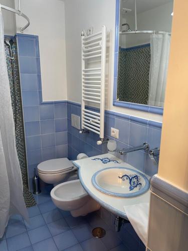 ein blau gefliestes Bad mit WC und Waschbecken in der Unterkunft Casa Elisa in Positano