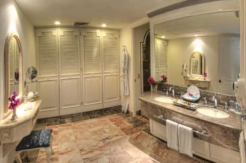 La salle de bains est pourvue de 2 lavabos et d'un grand miroir. dans l'établissement Hotel & Museo Casa Turquesa, à Cancún