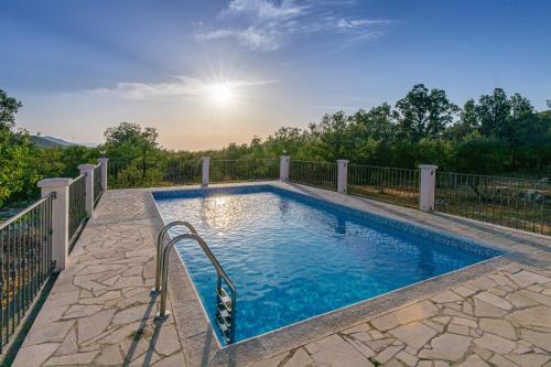 a swimming pool on a patio with a fence at Villa Menalo in Neum