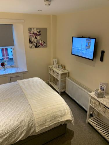 a bedroom with a bed and a television at Black Bull with Rooms in Cumbernauld