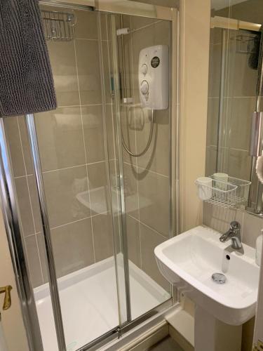 a bathroom with a shower, sink, and toilet at Black Bull with Rooms in Cumbernauld