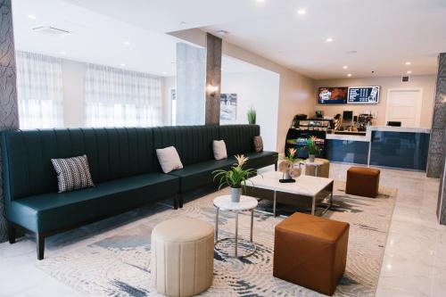 a living room with a green couch and tables at Hotel Legends in Biloxi