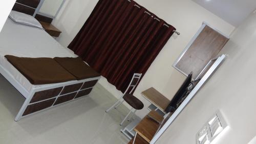 a small room with a bed and a chair at Anand P G hostel males only in Nagpur