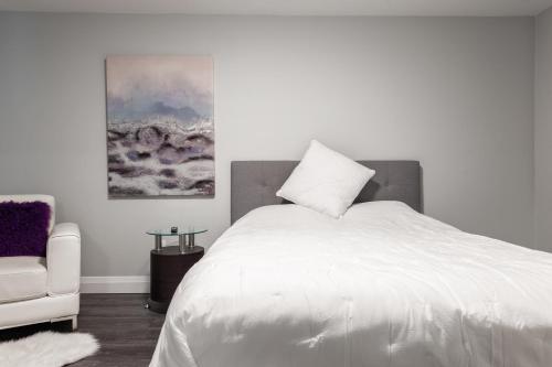a bedroom with a white bed and a chair at PRIVATE ROOM ENSUITE UPTOWN WATERLOO - e5 in Waterloo