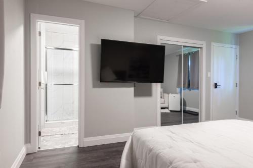 a bedroom with a flat screen tv on the wall at ENTIRE BACHELOR UNIT EN-SUITE UPTOWN WATERLOO - e5 in Waterloo