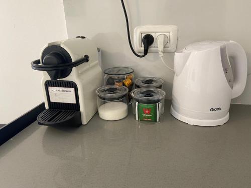 a kitchen counter with a coffee maker and jars at פנינת הדקל בבאר אורה in Beʼer Ora