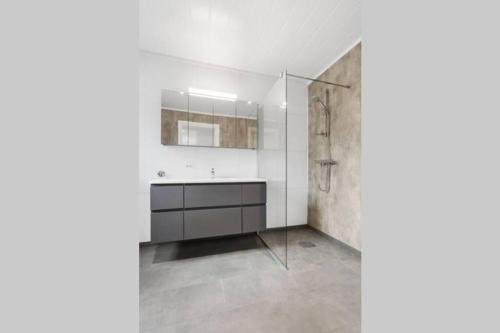 a bathroom with a sink and a mirror at Gjermundsøya Brygge in Ballstad
