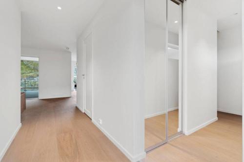 an empty hallway with white walls and mirrors at Gjermundsøya Brygge in Ballstad
