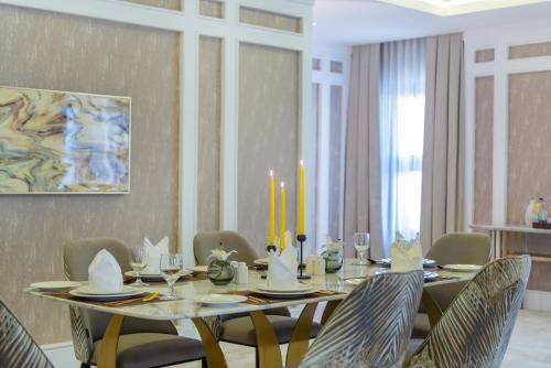 a dining room with a table with chairs and candles at Vittori Palace Hotel and Residences in Riyadh