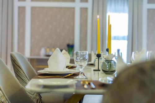 a dining table with a candle and plates and glasses at Vittori Palace Hotel and Residences in Riyadh