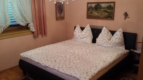 sypialnia z łóżkiem z czterema poduszkami w obiekcie Bungalow Möwe w mieście Pörtschach am Wörthersee