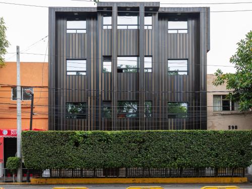 a tall building with a hedge in front of it at Hotel Vista Alegre in Mexico City