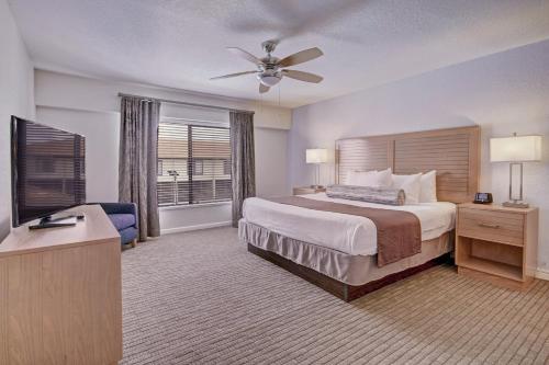a large hotel room with a bed and a window at Club Wyndham Orlando International in Orlando