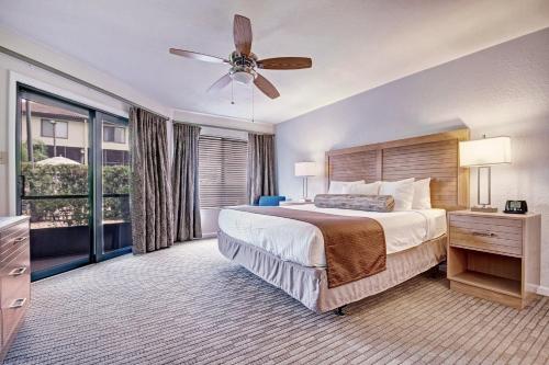 1 dormitorio con 1 cama grande y ventilador de techo en Club Wyndham Orlando International, en Orlando