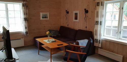 uma sala de estar com um sofá e uma mesa em Rugsund Handelsstad em Rugsund
