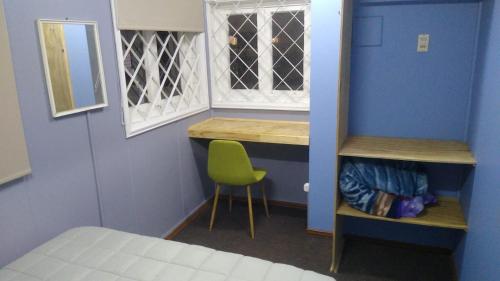 a room with a bed and a chair and a window at Islanet Hostel & Bar in Puerto Montt