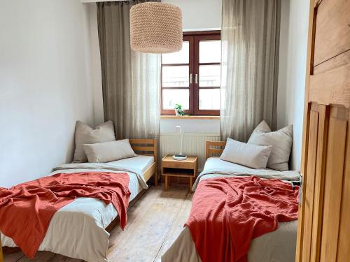 two beds in a small room with a window at Ferienwohnung Ava - Heiligkreuztal in Heiligkreuztal
