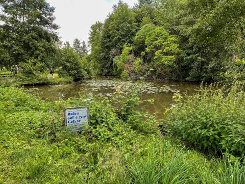 a sign in the grass next to a river at Ferienwohnung Ava - Heiligkreuztal in Heiligkreuztal