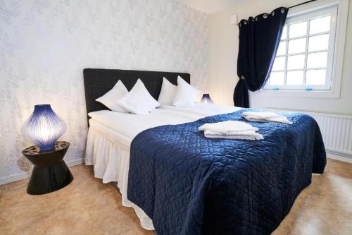1 dormitorio con 1 cama con manta azul y ventana en Folkarbo Vandrarhem, en Avesta