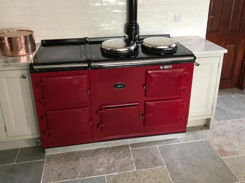 a red stove with two pans on top of it at Andresna House in Corrigeenroe