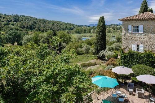 an outdoor patio with umbrellas in front of a building at Le Manoir de L'Étang in Mougins