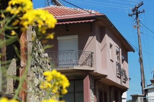 a building with a balcony and yellow flowers in front at Casa Mular in Kruševo