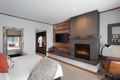 a bedroom with a fireplace and a bed and a tv at Salish Lodge & Spa in Snoqualmie