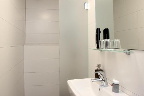 a white bathroom with a sink and a mirror at Forsthaus am Möhnesee in Möhnesee