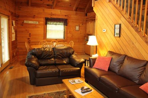 a living room with a leather couch and a table at Country Road Cabins in Hico
