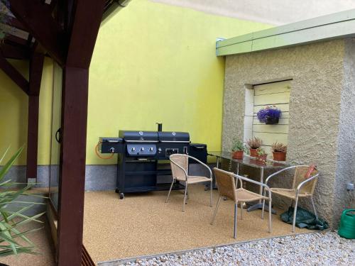 a patio with a grill and chairs and a table at Šenk U Kovárny in Mariánské Lázně