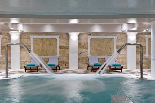 a swimming pool with two chairs and a swimming pool at Dolce by Wyndham Athens Attica Riviera in Vravrona