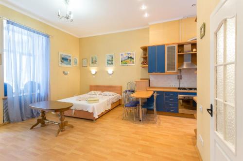 a bedroom with a bed and a table and a kitchen at Central Area Apartments in Kyiv