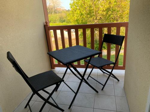 deux chaises et une table sur un balcon dans l'établissement À COTÉ DE LA BAIE DE CANCHE-Appt 4pers-Linge compris-Lits faits-1CHB 1 lit double-1CABINE 1 lit superposé-2SDB-piscine-parking-boulodrome-tennis, à Le Touquet-Paris-Plage