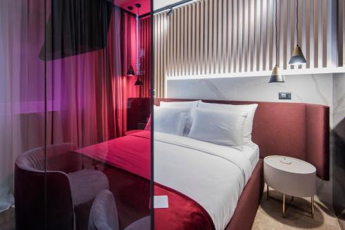 a bedroom with a large bed and a chair at Pod Zidom Rooms in Zagreb