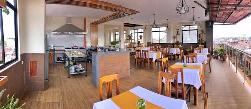 a restaurant with tables and chairs and a kitchen at Studio 69 Aparthotel in Iquitos