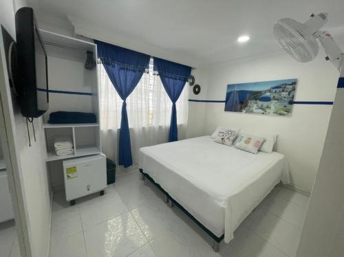 a small bedroom with a bed and a television at Casa Hotel Manco Mora in Medellín