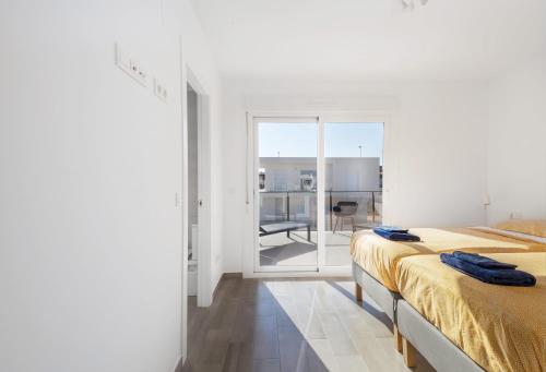 Dieses weiße Zimmer verfügt über 2 Betten und eine Glasschiebetür. in der Unterkunft Casa Bos Flamingo Luxury Wellness Entire Villa Pool Jacuzzi Gran Alacant near Beach in Puerto Marino