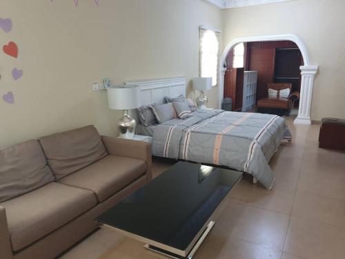 a living room with a bed and a couch at TeamVilla in Accra