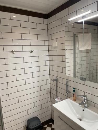 ein weißes Badezimmer mit einem Waschbecken und einem Spiegel in der Unterkunft Market place Jakobstad Pietarsaari 53m2 in Pietarsaari