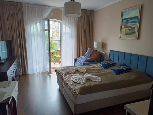 a bedroom with a large bed and a television at Apartament Regina Maris in Świnoujście