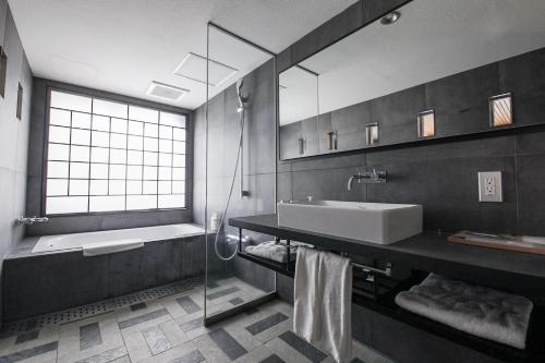 a bathroom with a sink and a tub and a mirror at Asakusa Kokono Club Hotel in Tokyo