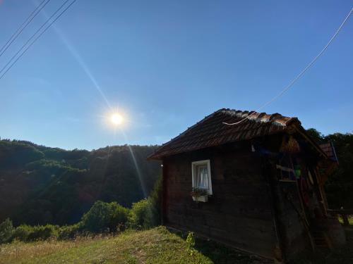 a house on a hill with the sun behind it at Turizam Raković in Ivanjica