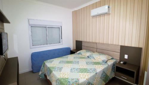 Un dormitorio con una cama azul y una ventana en 1070 - Praia de Bombinhas locação de temporada., en Bombinhas