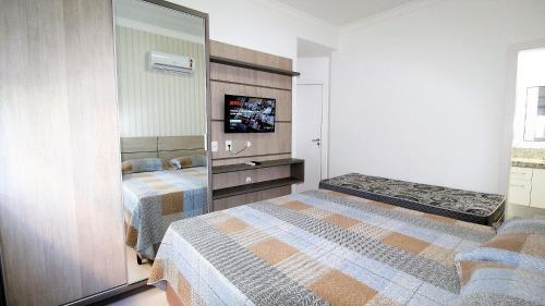 1 dormitorio con 2 camas y espejo en 1069 - Praia de Bombinhas locação de temporada, en Bombinhas