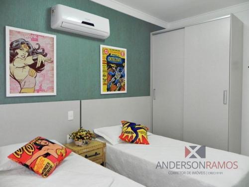 Dos camas en una habitación con dos posters en la pared en 1056 - Apartamento para locação na praia de Bombinhas, en Bombinhas