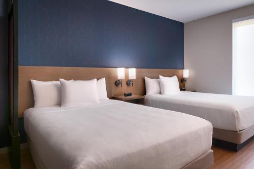 two beds in a hotel room with two beds at Hyatt Place Fayetteville/Springdale in Fayetteville