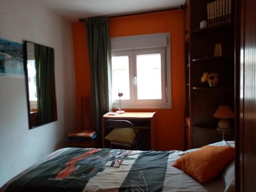 1 dormitorio con cama, ventana y escritorio en Habitación silenciosa cerca del Hospital valdecilla, en Santander