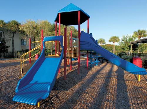 a playground with a blue slide in a park at Club Wyndham Orlando International in Orlando