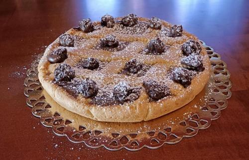 a chocolate cake on a glass plate on a table at Mille e una notte in San Severino Lucano