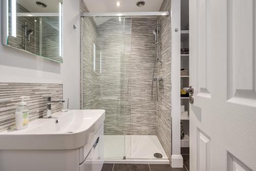 a bathroom with a sink and a glass shower at Melrose Townhouse in Belfast